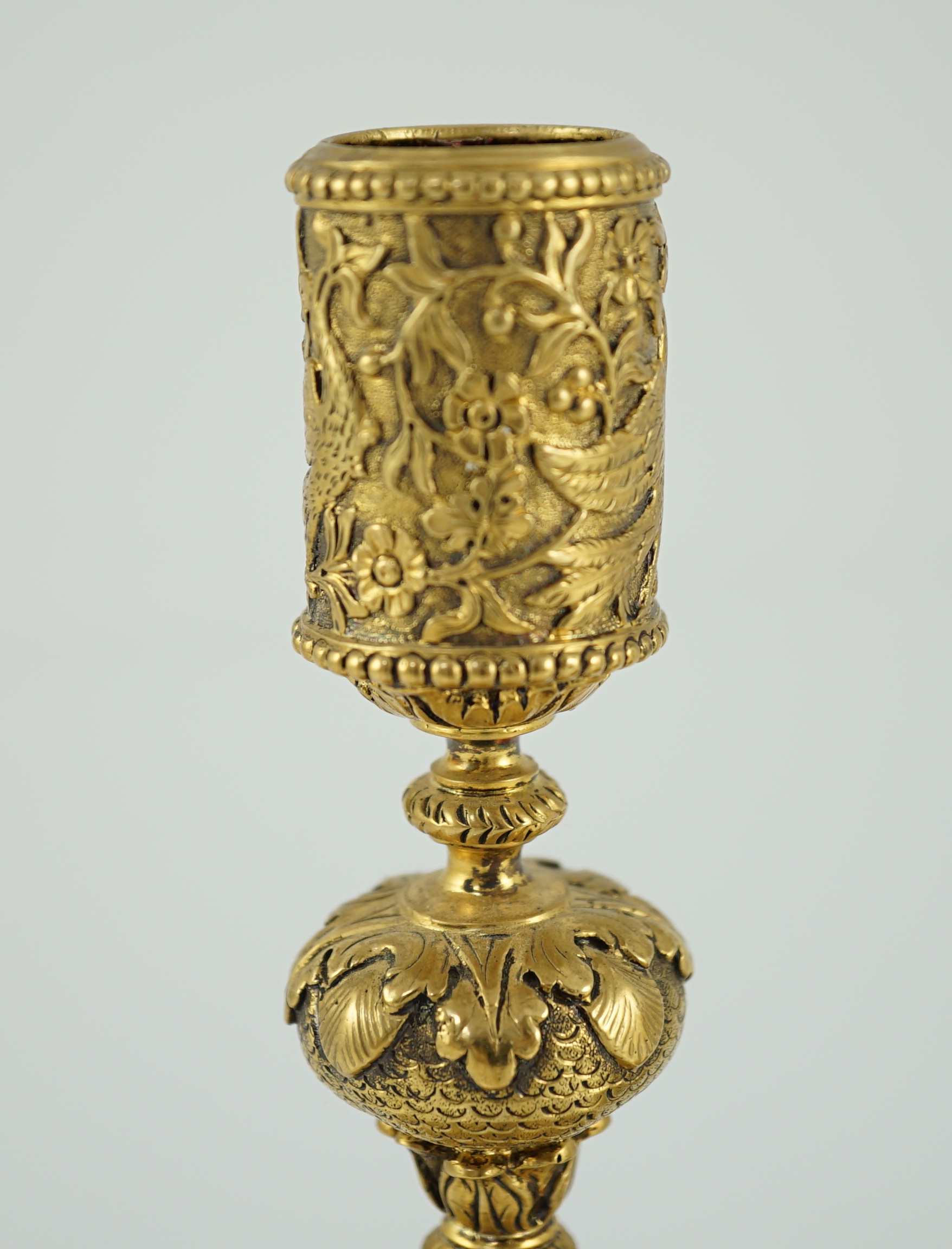 An ornate pair of Victorian silver gilt dwarf candlesticks, by John Wilmin Figg